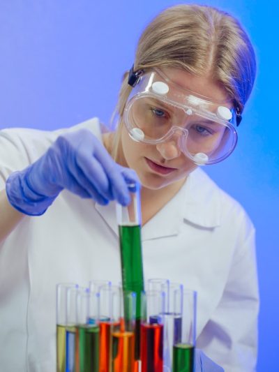 A scientist holds a test tube containing mysterious coloured liquid