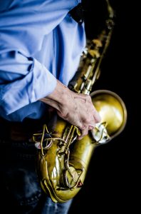 Person in scrubs playing the saxophone. Image by César Guadarrama Cantúa