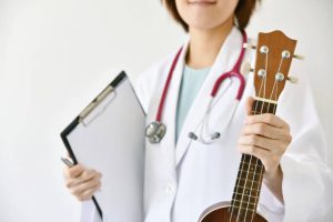 Doctor holding a clipboard and a ukelele